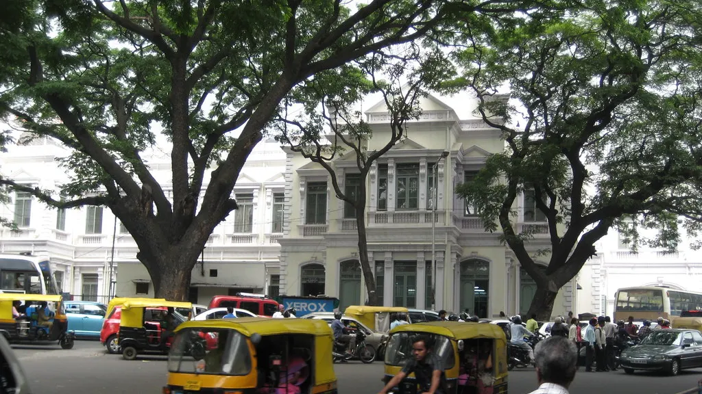Auto-rickshaws on a tree-lined road in Bengaluru